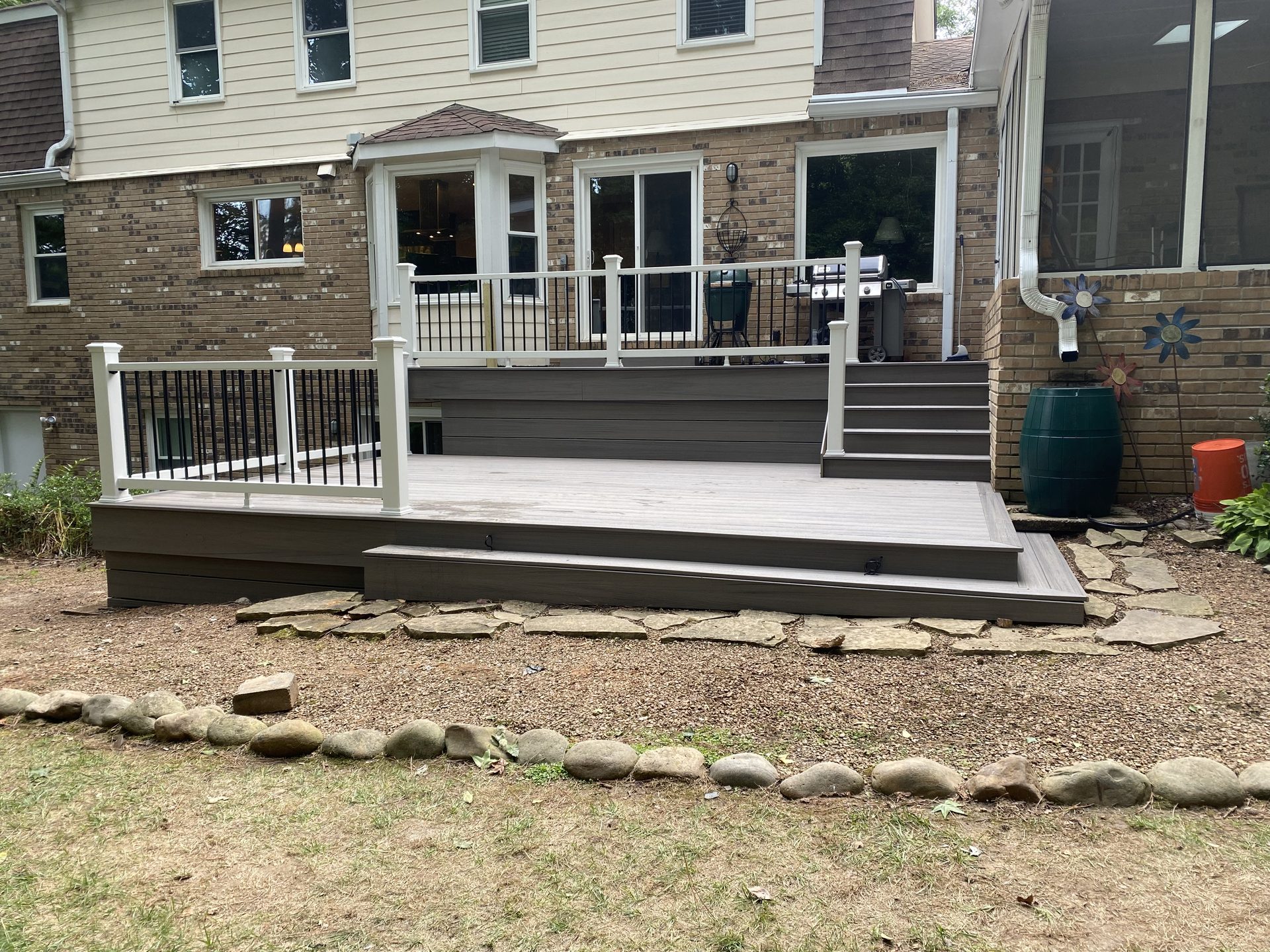 Multi-level backyard deck with white and black railing
