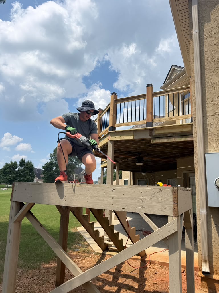 B&T crew member cutting into an old deck frame during tear-off
